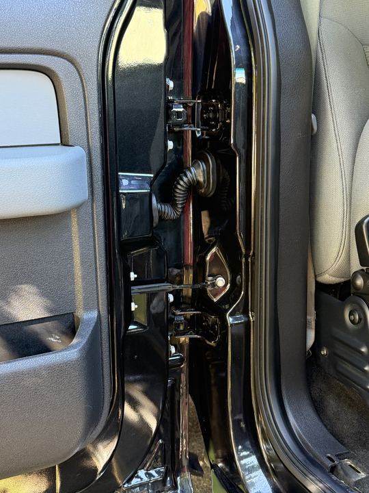 Clean, glossy door jamb and hinges with the door open
