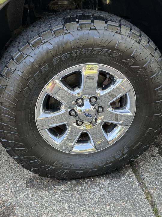 Cleaned chrome wheel and dressed all-terrain tire on the truck